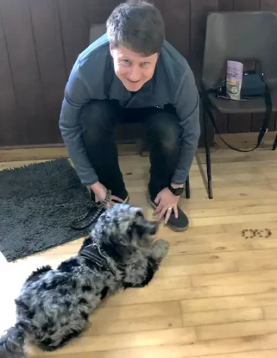 A dog owner and his dog pose for the camera during a dog training class.