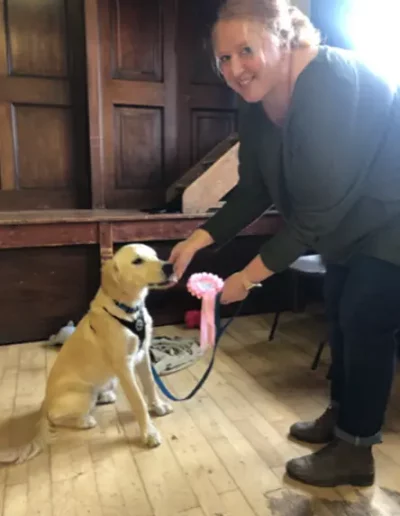 A dog owner with her dog having completed a dog training course.